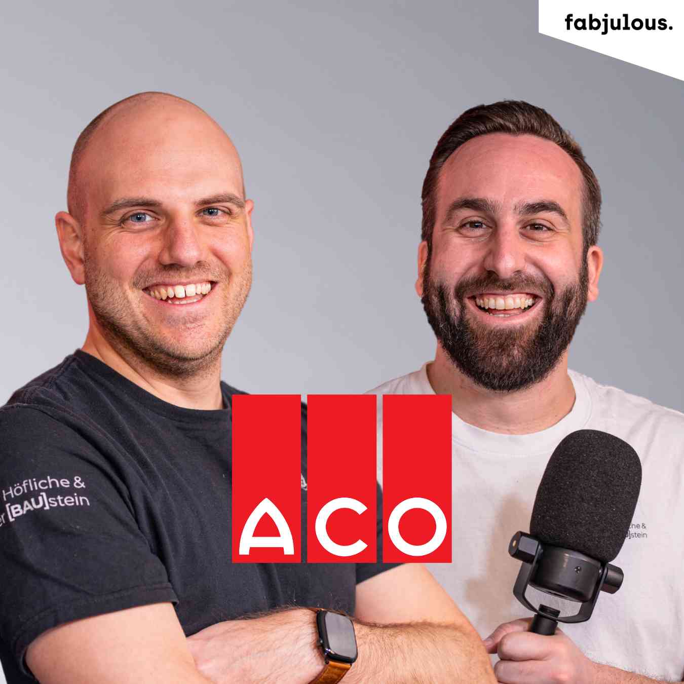Zwei Männer stehen lächelnd vor grauem Hintergrund, beide schauen in die Kamera. Mittig das rote ACO-Logo, rechts ein Mikrofon.