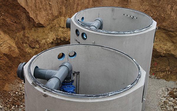 Zwei große Pumpstationen, installiert in einer Baugrube mit Erdreich.