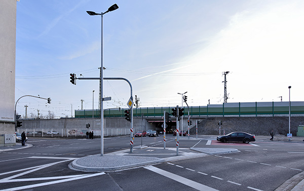 Stehende Autos vor Ampeln an einer Straßenkreuzung mit einem Tunnel im Hintergrund