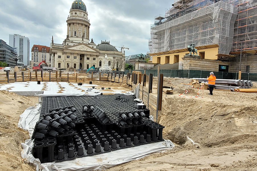 Blockrigolenssystem als Versickerungsanlage in einer Baugrube im Hintergrund der Deutsche Dom auf dem Gendarmenmarkt in Berlin.