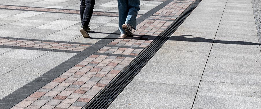 Rinnensystem fügt sich harmonisch in ein Natursteinpflaster mit seinem imposanten Mosaikmuster ein.