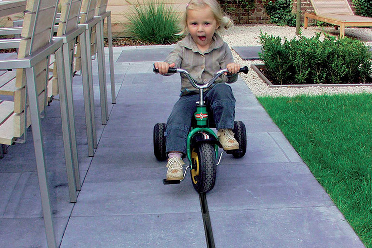 Schlitzrinne auf der Terrasse mit Kind auf Dreirad