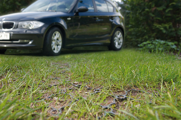 Auto steht auf Parkplatz mit Rasenwaben