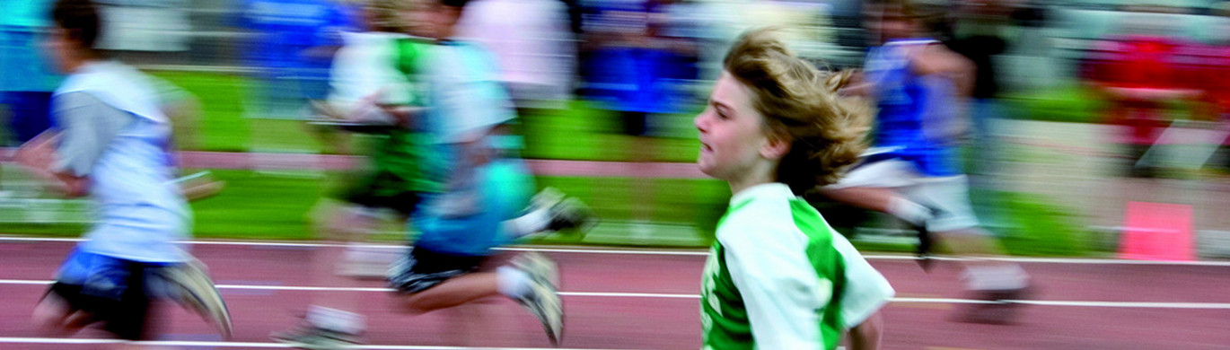 Laufen Kinder, die auf einer Tartanbahn rennen.