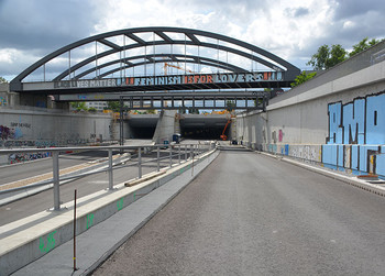 Tunnelentwässerung: Maßgeschneiderte Lösungen gefragt Straße mit Tunnel und Stabbogenbrücken, die Brücke und die Betonwände sind mit Graffiti bemalt.