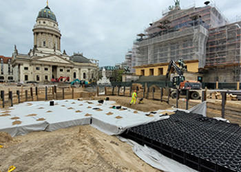 Blick auf die Baustelle des Gendarmenmarktes in Berlin mit Schauspielhaus und Dom im Hintergrund