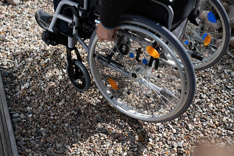 Rollstuhl auf Kiesweg