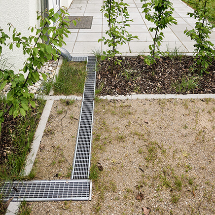 Das Regenwasser wird über das Fallrohr in die Rinne geleitet.