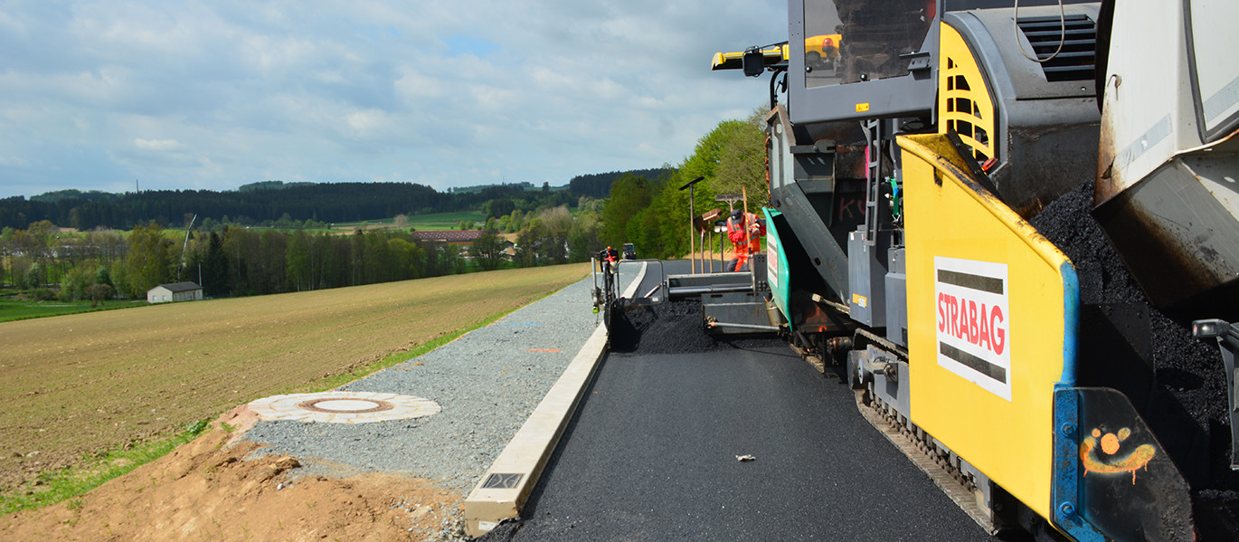 Sanierung der Staatstraße 2693 mit der Hohlbordrinne ACO DRAIN® Kerbdrain Road. Sie vereint den Bordstein mit der Entwässerungsrinne in einem Bauteil.